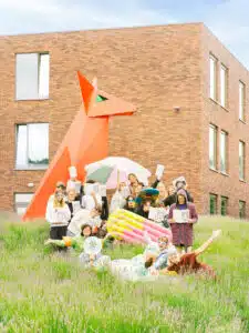 Leerlingen van Sint-Joris Bazel poseren voor een foto samen met het logo "Deze school duikt in taal"